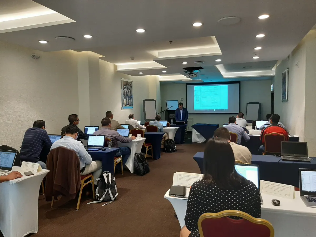 Participantes trabajando en computadoras portátiles durante una capacitación técnica